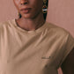 Femme portant un tee-shirt beige en coton biologique Maison Labiche avec une broderie sur le coeur Hello