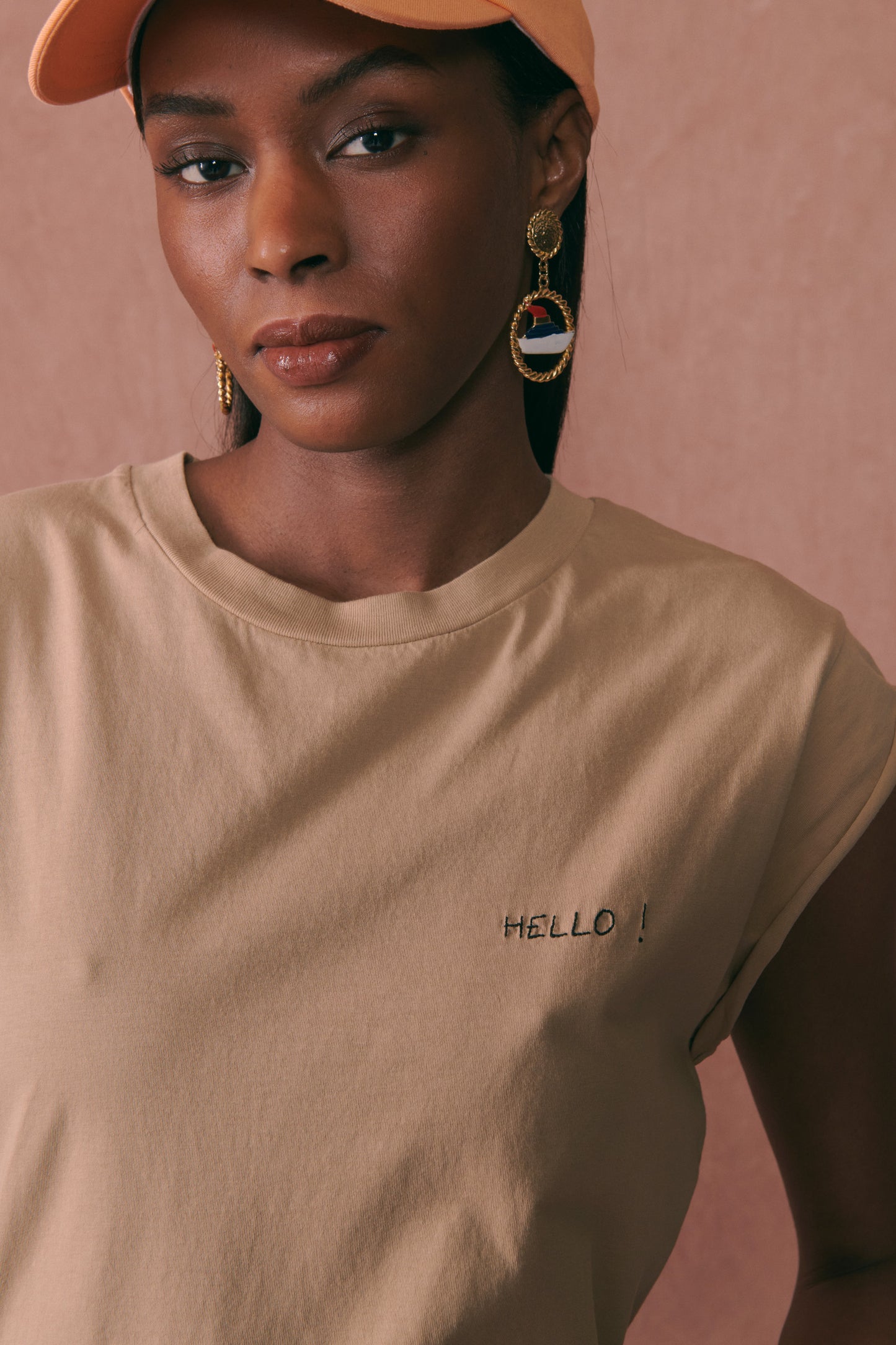 Femme portant un tee-shirt beige en coton biologique Maison Labiche avec une broderie sur le coeur Hello