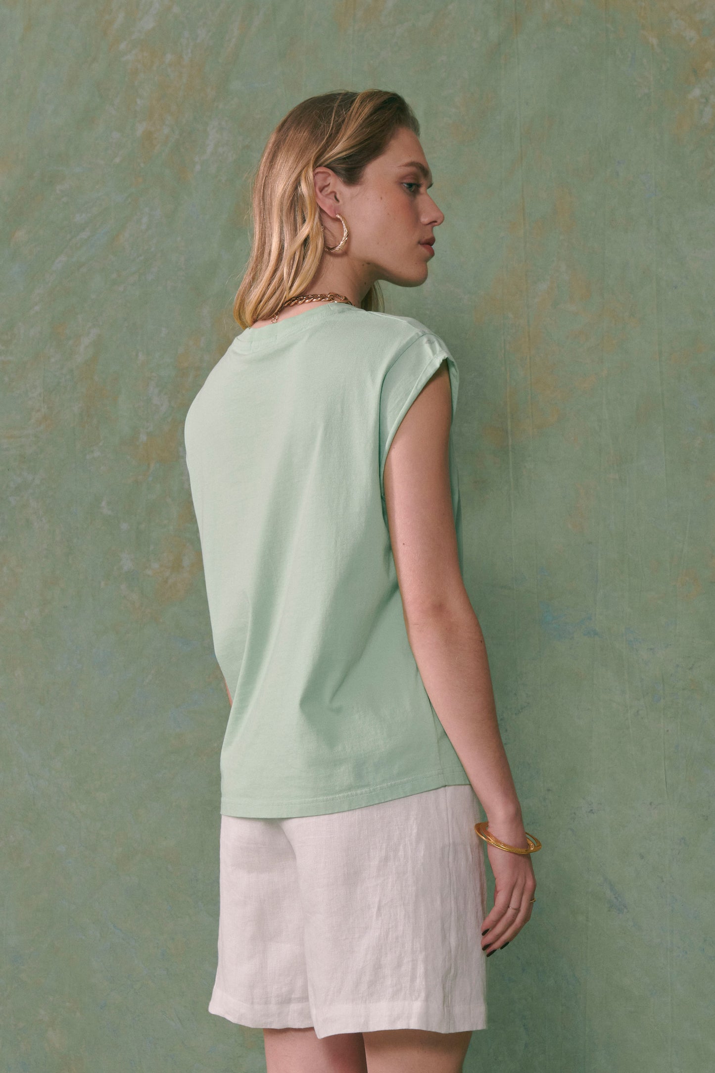 Femme portant un tee-shirt bio vert sans manche Maison Labiche vue de dos