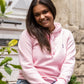 Femme assise en extérieur portant un hoodie rose éco-responsable fabriqué en France